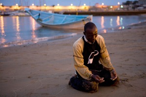 July 1, 2008: A man offer prayers of thanks after arriving at a beach on Spain's Canary island of Gran Canaria(Borja Suarez/Reuters)